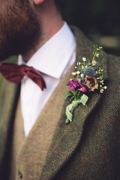 a man wearing a suit and tie with a flower boutonniere on his lapel