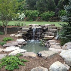 a small waterfall in the middle of a garden