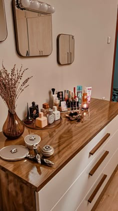 a wooden counter topped with lots of cosmetics and personal care items on top of it