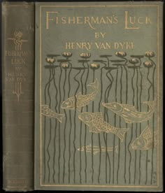 an old book with gold lettering on the front cover and two fish swimming in the water