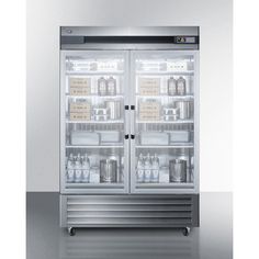 two glass doors on the front of a stainless steel refrigerator with milk and beverages in it