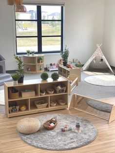 a child's playroom with toys and bookshelves on the floor in front of a large window