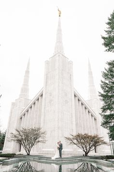 a bride and groom standing in front of the salt lake temple