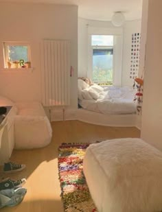 a bedroom with two beds and a rug on the floor in front of a window