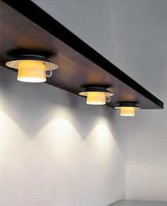 three lights are hanging from the ceiling in a room with white walls and flooring