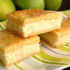 three pieces of cake sitting on top of a green and white plate next to some apples