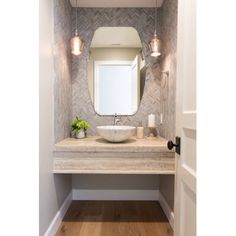 a bathroom with a sink, mirror and light fixture in it's center area