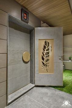 an open door to a bathroom with grass in the floor and paintings on the wall