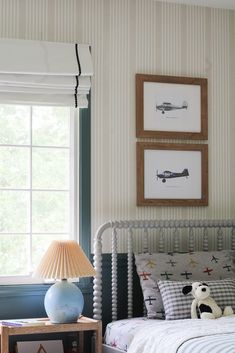 a bed room with a neatly made bed and two pictures on the wall