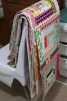 a quilted blanket sitting on top of a white chair