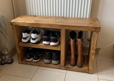 several pairs of shoes are lined up on a wooden shelf in front of a radiator