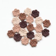 small crocheted flowers are arranged on a white surface