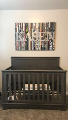 a baby crib in front of a painting on the wall