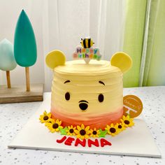 a winnie the pooh birthday cake with sunflowers