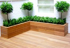 a wooden planter filled with trees on top of a hard wood floor