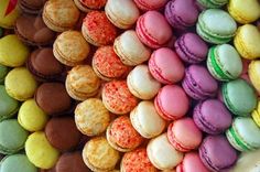 there are many different colored macaroons on display