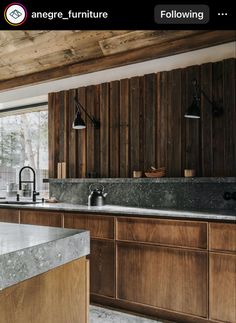 a kitchen with wooden cabinets and marble counter tops, along with an island in the middle