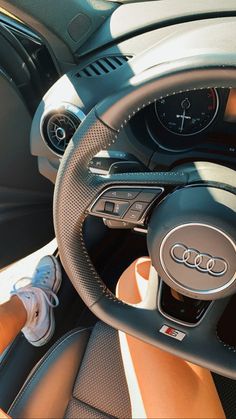 the interior of a car with steering wheel and gauges