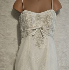 a woman's white wedding dress is displayed on a mannequin