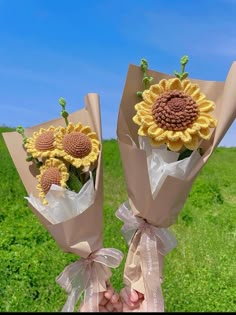 two sunflowers are wrapped in brown paper and tied with ribbon on the grass