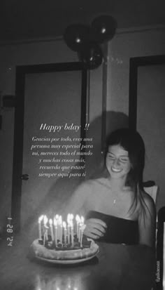 a woman sitting in front of a cake with lit candles on it and the caption reads happy birthday