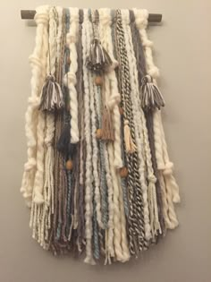 a wall hanging made out of yarn and tassels