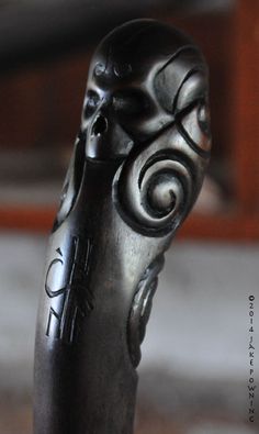 a close up view of a black object on a table with wood in the background