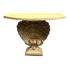 a gold shell shaped table on a white background