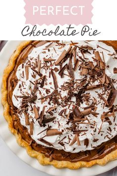 a pie topped with whipped cream and chocolate shavings is on a white plate