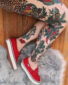 a woman with tattoos and red shoes on