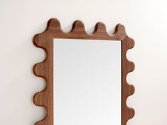 a wooden mirror hanging on the wall