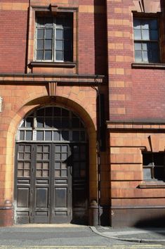 an old red brick building with two large doors and arched doorways on the side