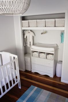 a baby's room with a crib, dresser and changing table in it