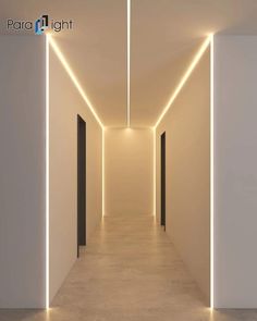 an empty hallway with white walls and lights on the ceiling is lit by recessed lighting