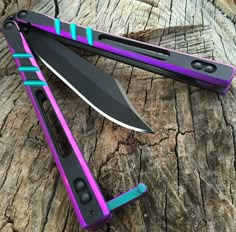 two purple and black knives sitting on top of each other