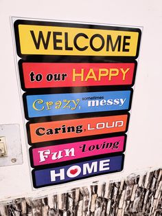 a welcome sign is posted on the side of a building that says, welcome to our happy crazy messy caring loud fun loving home