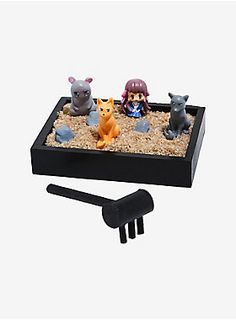 three small figurines sitting on top of a sand tray