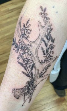 a deer's antlers with flowers and leaves on their horns are shown in this tattoo