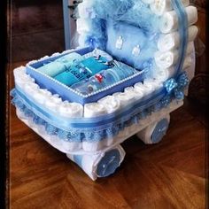 a baby's carriage shaped cake sitting on top of a wooden floor next to a window