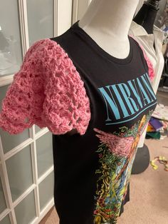 a mannequin wearing a black shirt with pink crochet on the sleeves