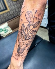 a person with a tattoo on their leg holding a light bulb and flowers in it