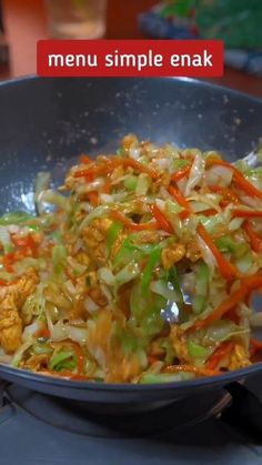 a wok filled with lots of food on top of a table