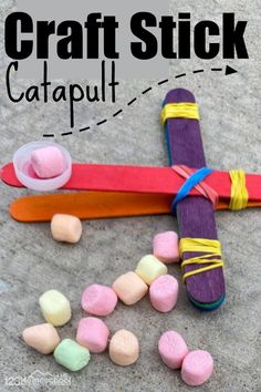 an airplane made out of candy sticks and marshmallows on the ground with text overlay that reads craft stick catapult