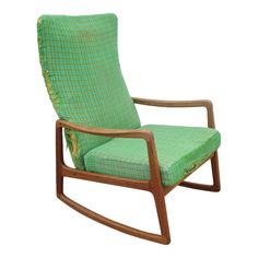 a wooden rocking chair with green fabric on it