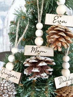 a pine cone christmas tree with wooden name tags on it