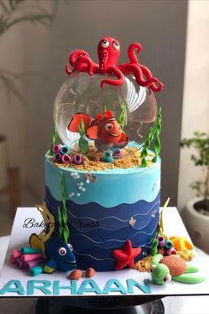 a birthday cake decorated with an ocean scene and under the sea animals in a fish bowl