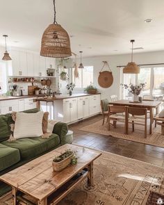 a living room filled with furniture next to a kitchen and dining room table on top of a hard wood floor