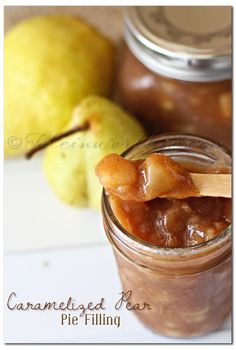 a jar filled with caramelized pear pie filling on top of a table next to two pears