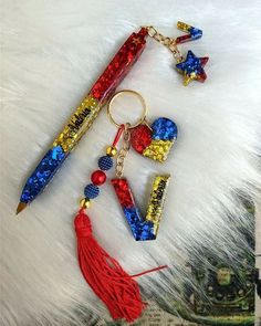 a red, white and blue keychain with some writing on it next to a pair of scissors