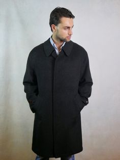 This 1990s German vintage black Loden wool coat has a wing collar and closes in the front with four concealed buttons (and there is a leather button at the neckline if you want to close the coat fully). The handsome overcoat has two pockets on the front, and the back features a yoke and long inverted pleat. Size: Extra Large Material: 95% Tiroler Loden Wool, 5% Polyamide Condition: Excellent (Professionally Cleaned ... soft and supple, with no stains, tears, wear spots, or weaknesses in the seam Formal Black Wool Coat With Buttons, Classic Brown Wool Coat With Button Closure, Classic Black Wool Coat With Concealed Placket, Classic Brown Wool Coat For Business, Black Single-breasted Pea Coat For Tailoring, Black Long Wool Coat With Button Closure, Classic Black Wool Coat With Long Sleeves, Classic Black Wool Coat With Pockets, Classic Black Wool Outerwear